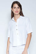 Woman wearing a white button-up shirt against a light gray background