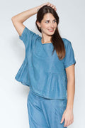 Woman wearing a blue outfit against a white background