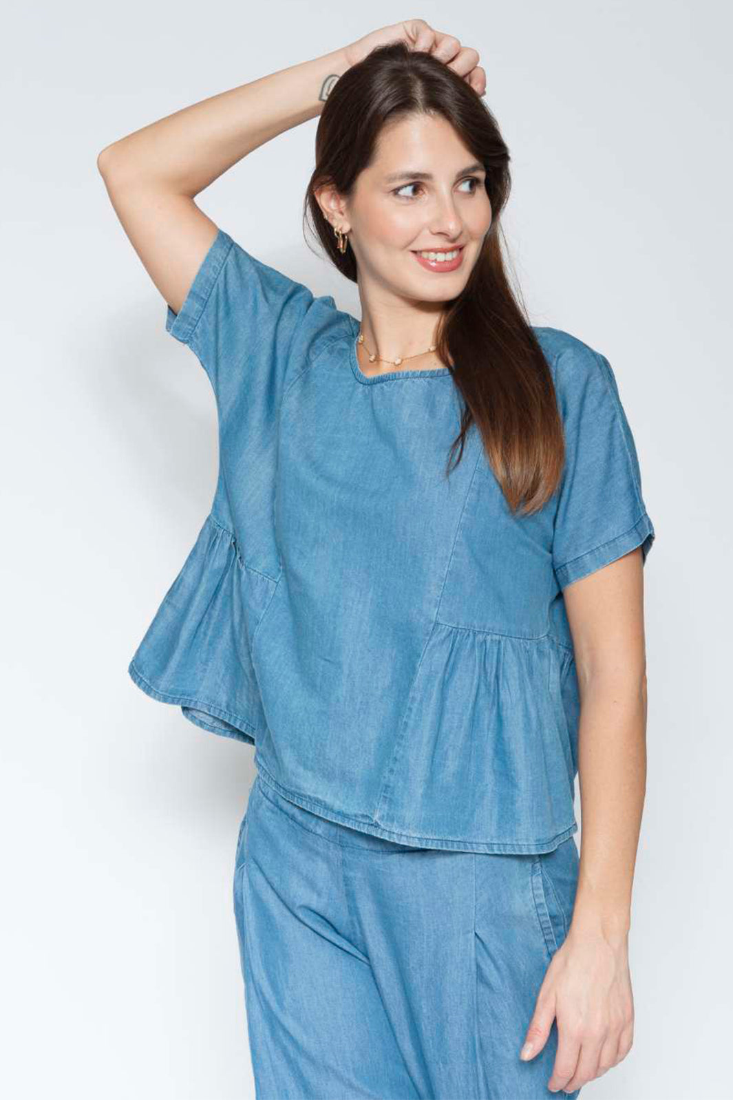 Woman wearing a blue outfit against a white background