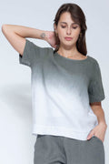 Woman wearing a gray and white gradient t-shirt against a plain background