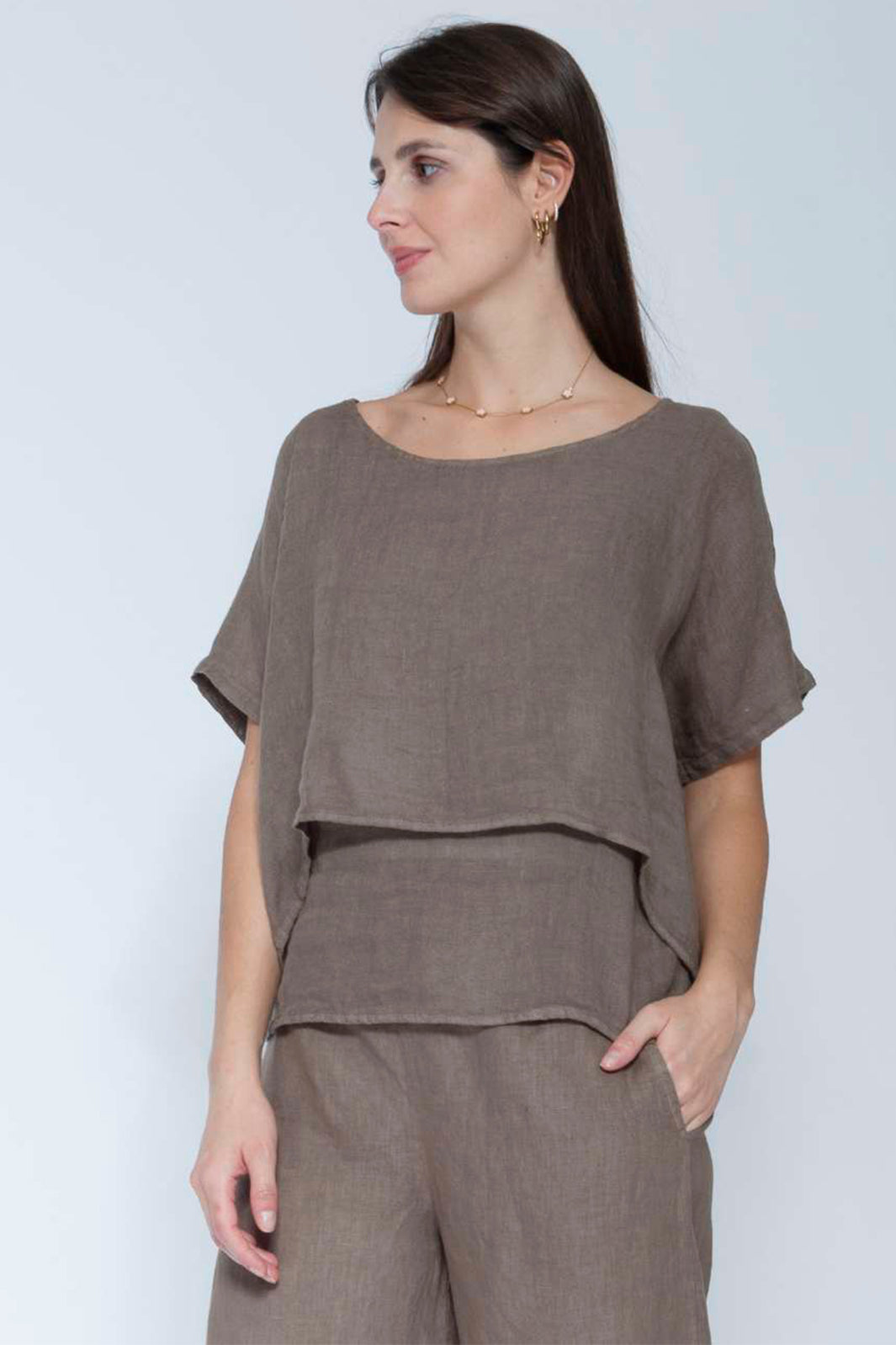 Woman wearing a brown outfit against a white background