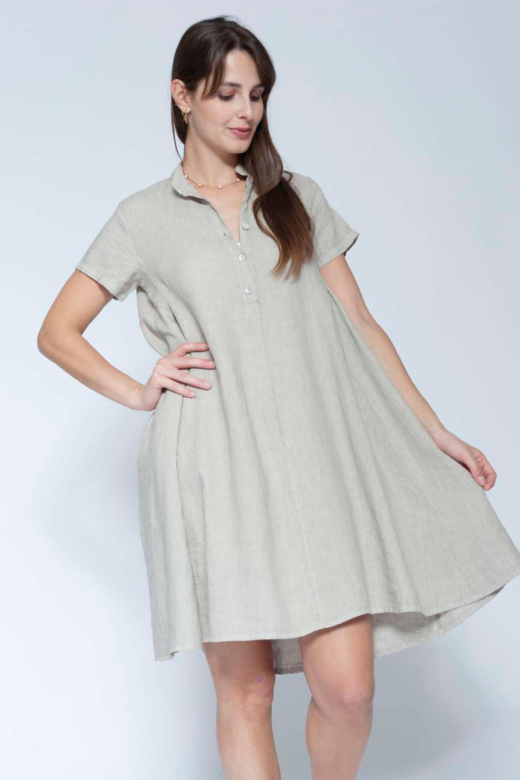 Woman wearing a light gray dress against a white background