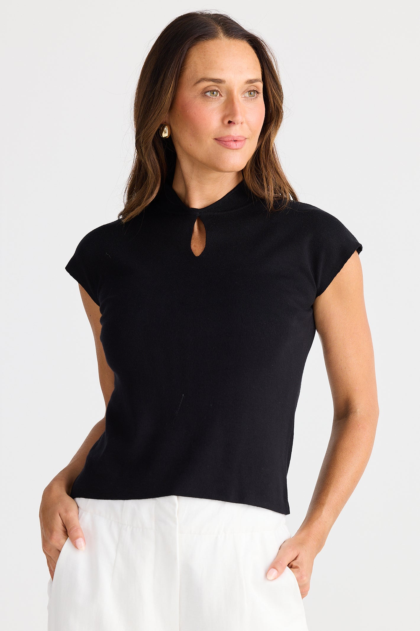 Woman wearing a black top with a cut-out detail on a white background