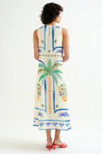 Woman wearing a sleeveless dress with a tropical pattern on a white background