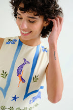 Person wearing a sleeveless top with colorful designs on a white background