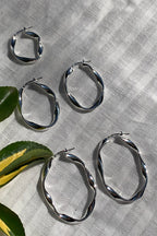 LBJ Jewellery Medium Oval Twist Silver Hoops E1662/3, three sizes on linen