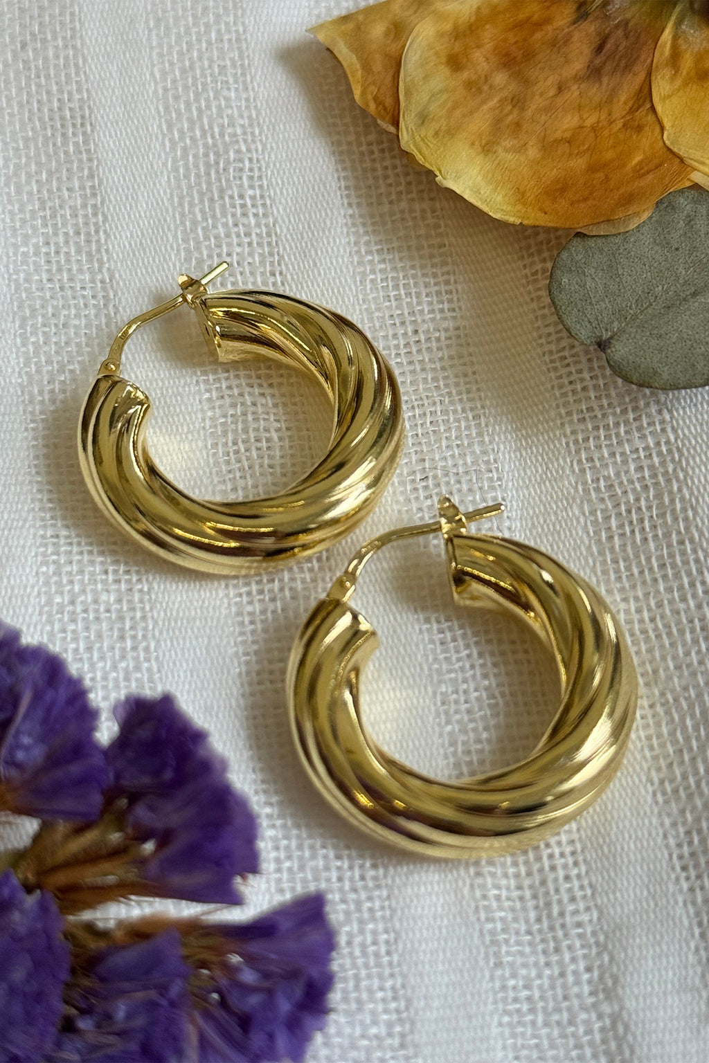 LBJ Jewellery Thick Medium Twist Hoops Gold Plated E134GP, styled with dried flowers