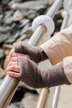 Turtle Doves Camel Brown Cashmere Fingerless Gloves, worn on hands holding a railing