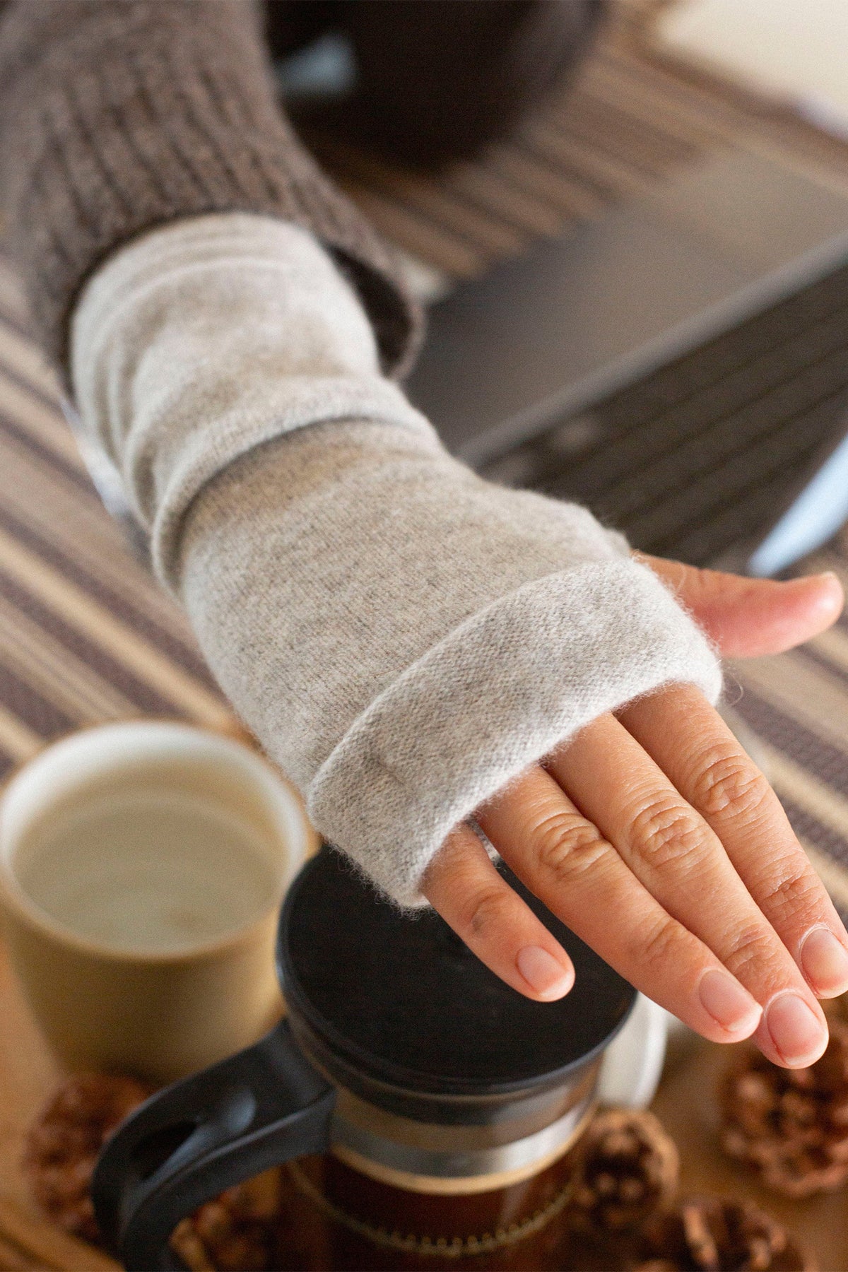 Turtle Doves Grey Cashmere Fingerless Gloves, worn on hand with coffee