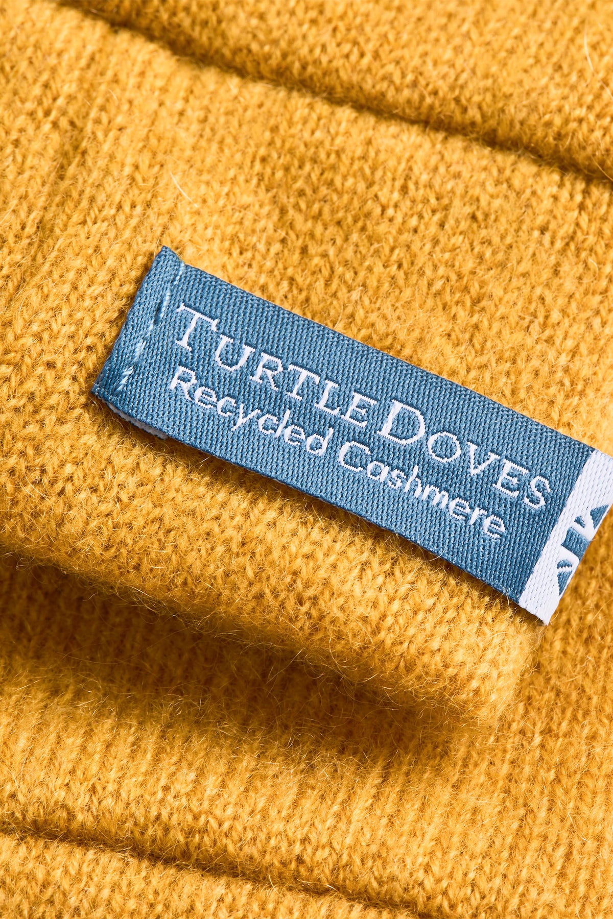 Turtle Doves Mustard Yellow Cashmere Fingerless Gloves, cuff label close-up