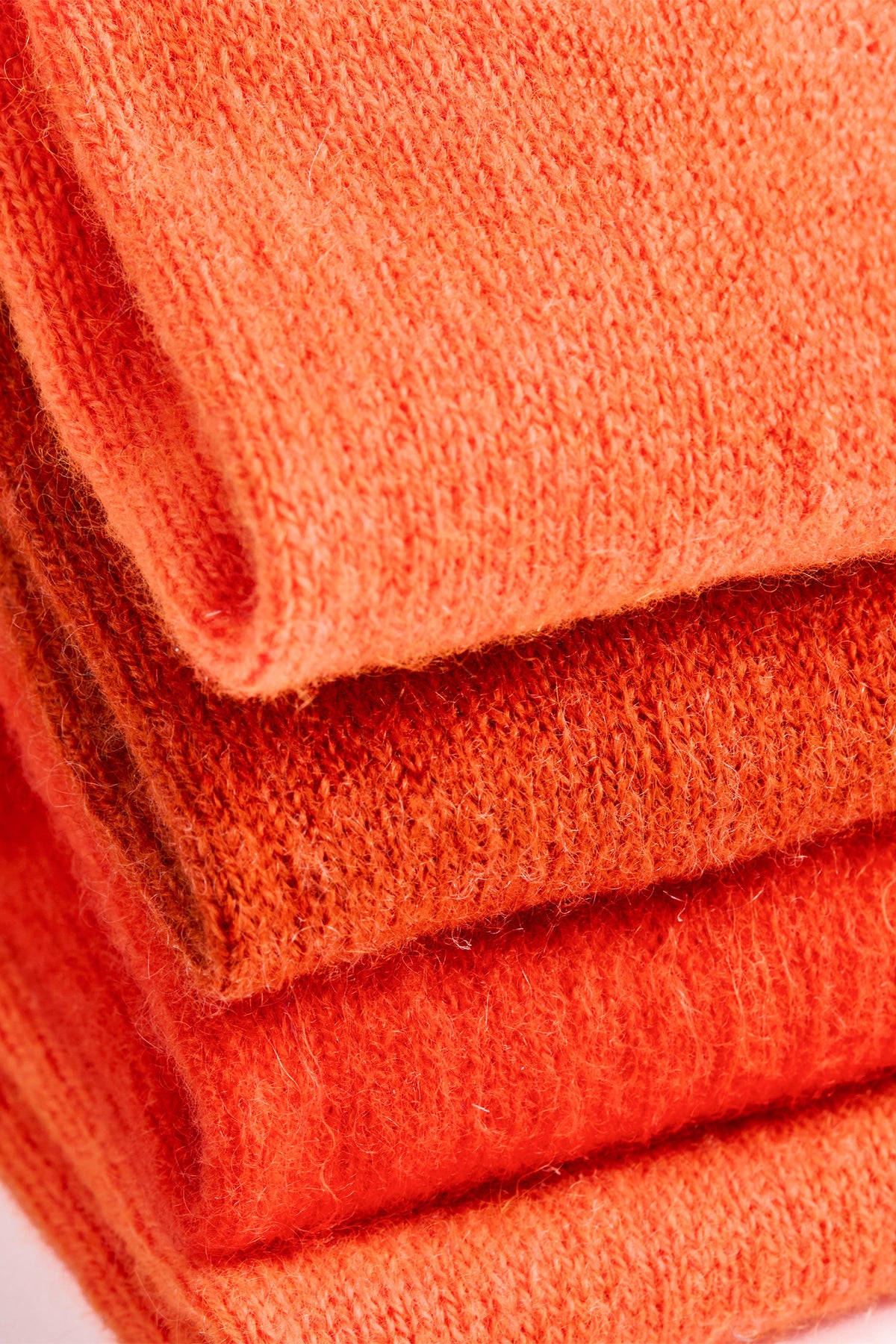 Turtle Doves Orange Cashmere Fingerless Gloves, folded stack
