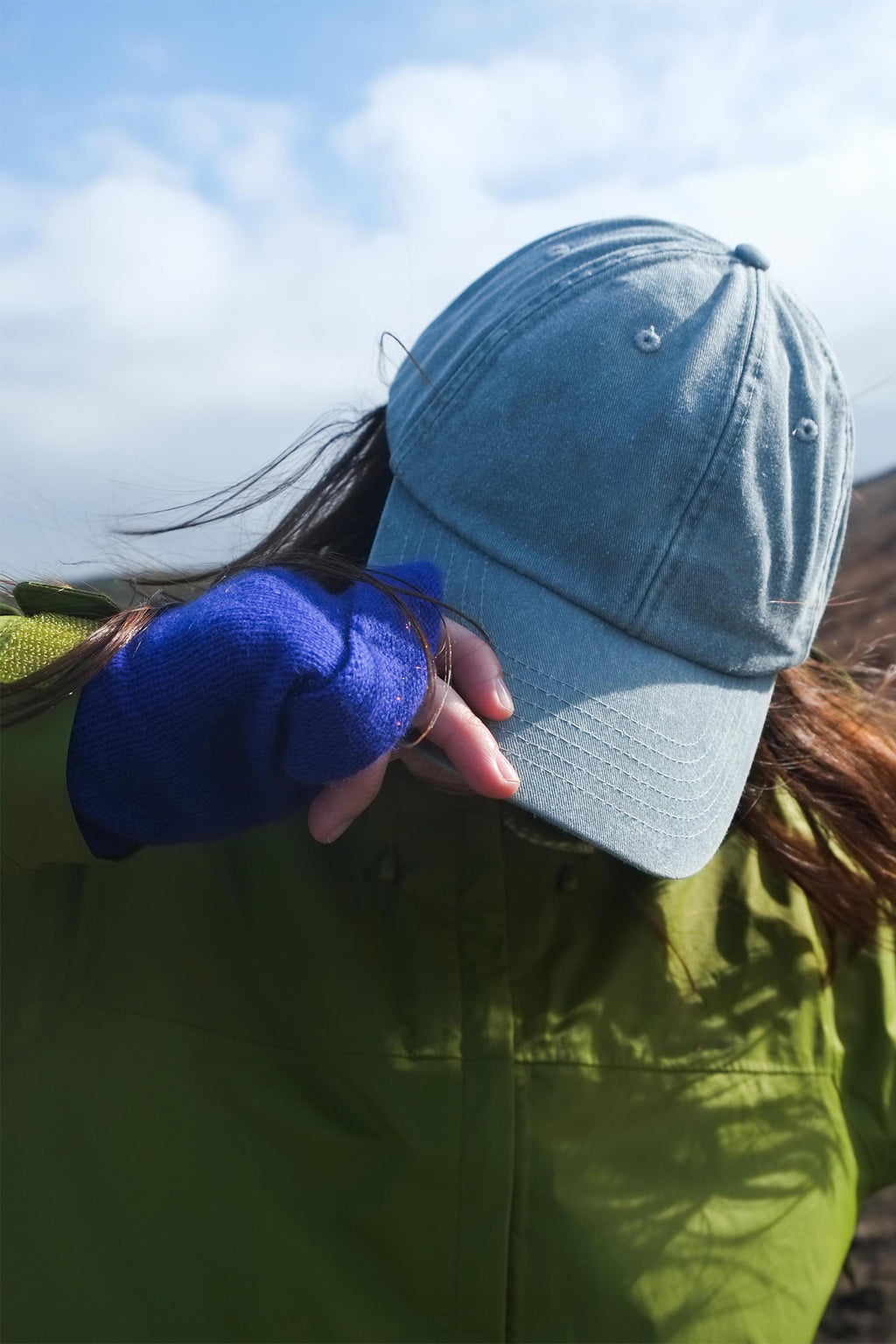 Turtle Doves Royal Blue Cashmere Fingerless Gloves, worn outdoors with a cap