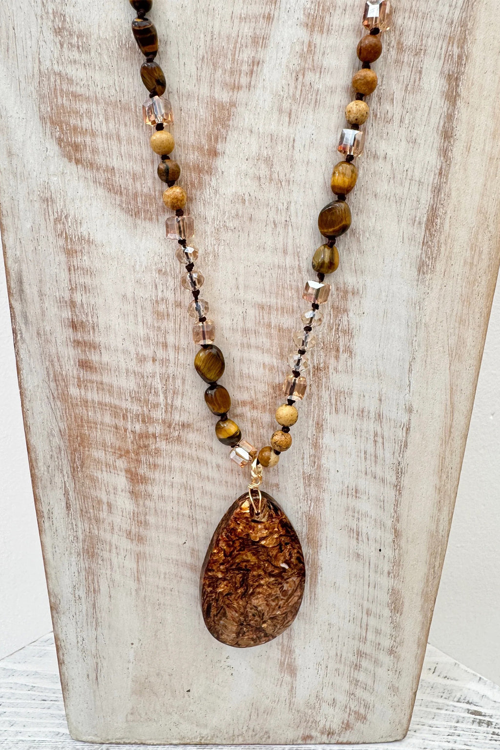 Wild Spirit Desert Dunes Brown Necklace, on display stand, pendant detail