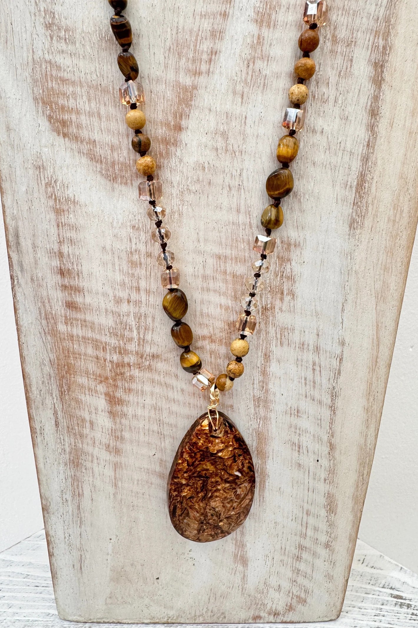 Wild Spirit Desert Dunes Brown Necklace, on display stand, pendant detail