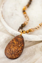 Wild Spirit Desert Dunes Brown Necklace, pendant close-up on fabric