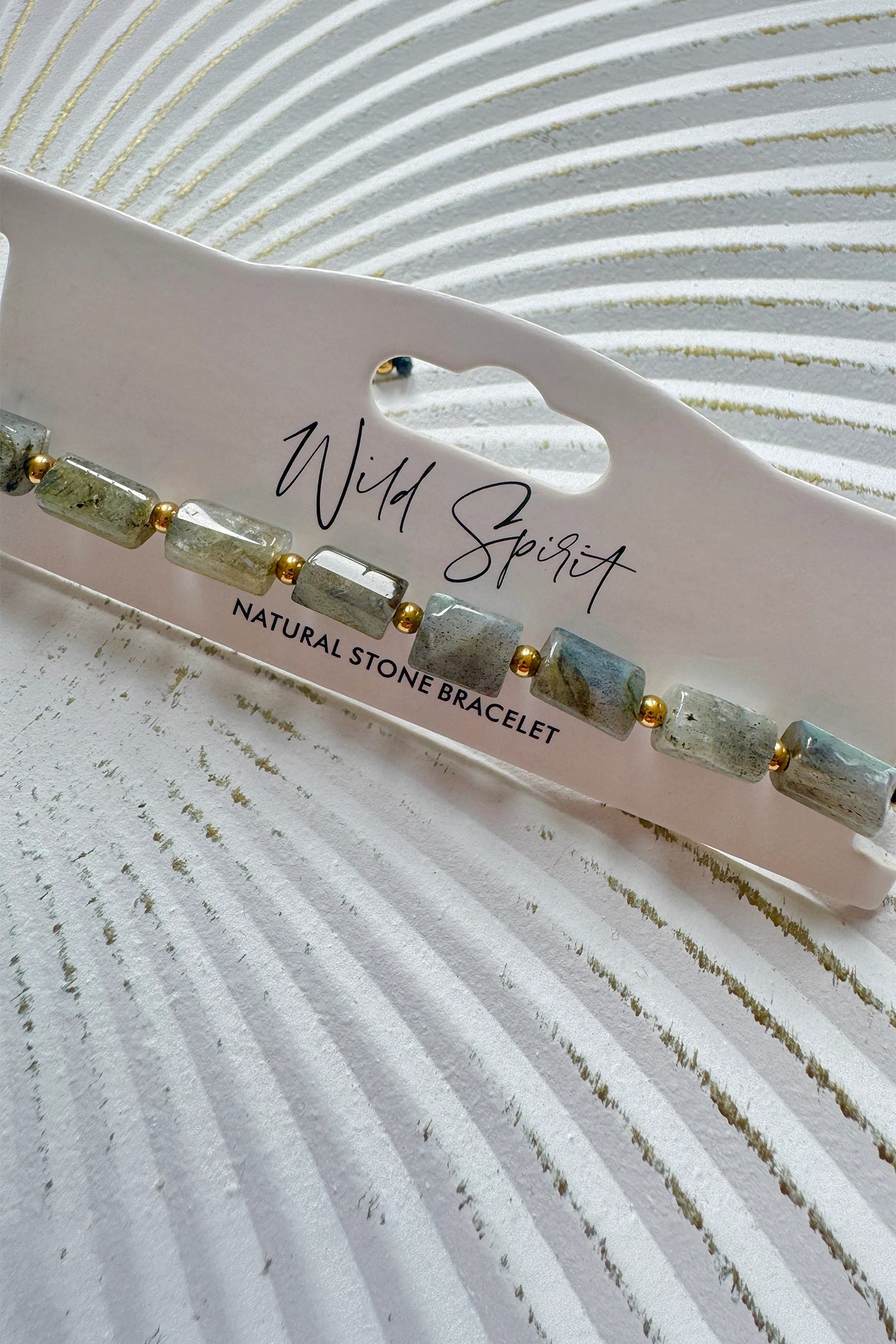 Wild Spirit Labradorite Grey Rock Bracelet, angled close-up on branded card
