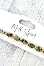 Wild Spirit Dalmatian Beige Nomad Bracelet, close-up on branded card